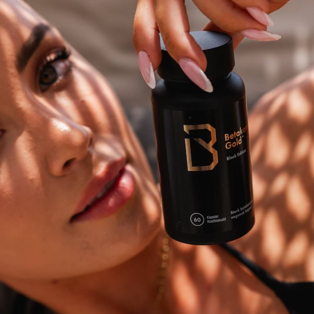 Woman holding a Betakaroten Gold Black bottle