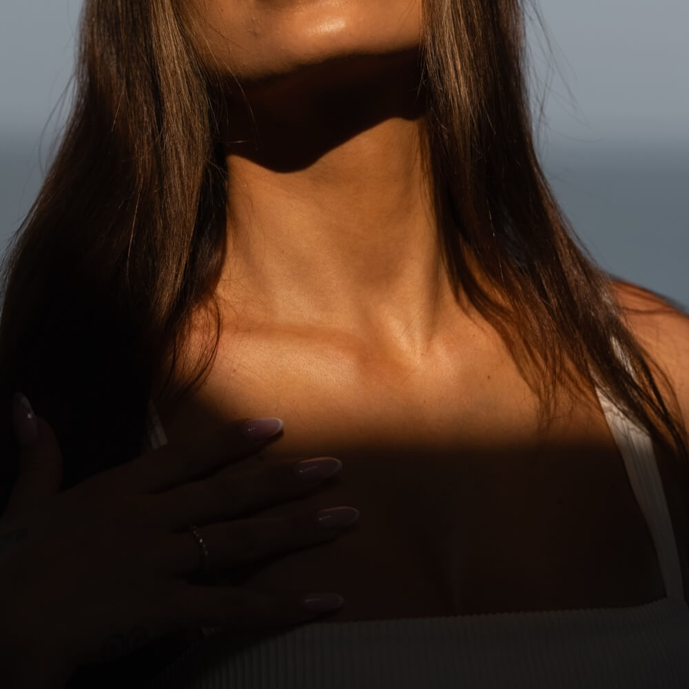 Woman's neck and shoulders in soft light and shadow